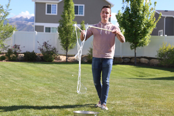 Boy holding DIY bubble wand with sticks together