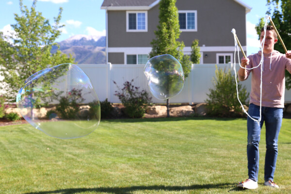 Boy blowing big bubbles with DIY bubble wand