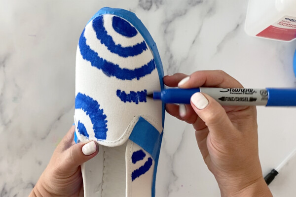 Drawing rings of color with a sharpie on a white canvas shoe