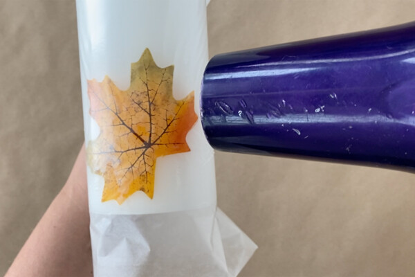 Candle with leaf wrapped in wax paper; hair dryer