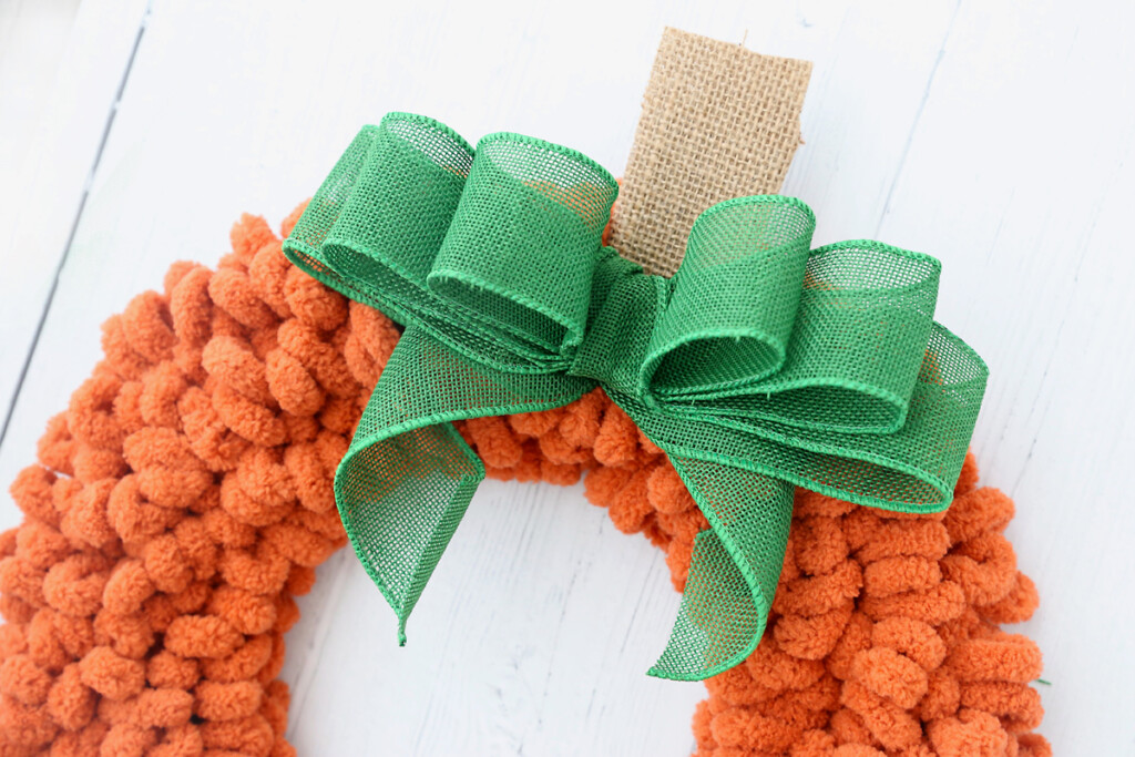Green bow on the top of a pumpkin wreath