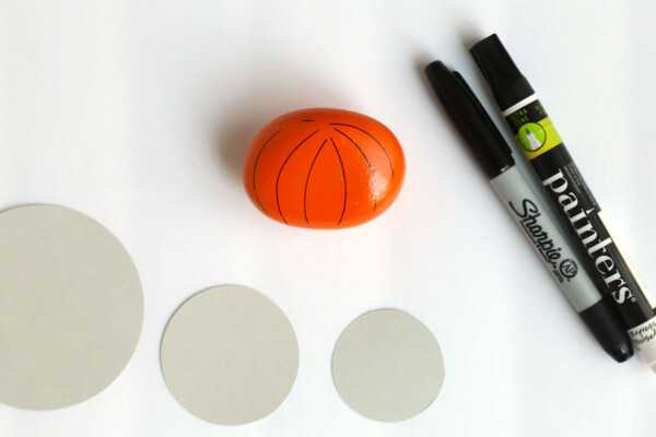 Rock painted orange with card stock circle templates and paint pens
