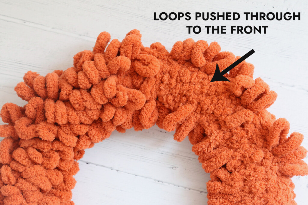 Wreath form covered with loop yarn; loops pushed through to the front