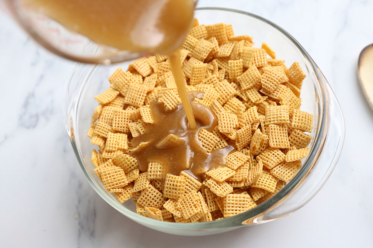 Pouring caramel sauce onto bowl of Chex cereal