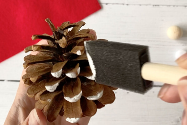 painting edges of pinecone white