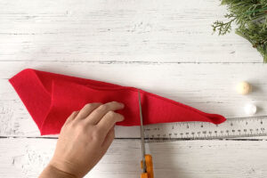 Piece of red felt folded in quarters from one corner; cutting it