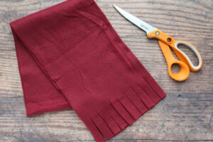 Red scarf with ends fringed, scissors