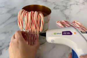 Seven candy canes placed inside the rubber band around the can