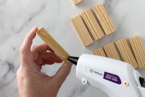 Placing hot glue on long side of wood block