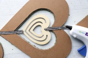Ribbon used to hold smaller wood heart in center of larger wood heart.