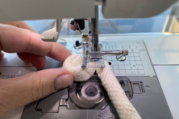 Spiral of rope placed on a sewing machine under the presser foot.