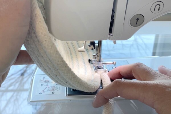 Lifting the left side of the base as high as it will go to sew the sides of the bowl.