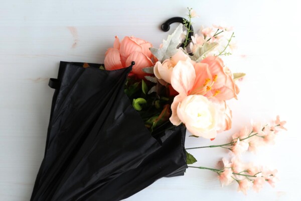 Faux flowers placed inside a black umbrella