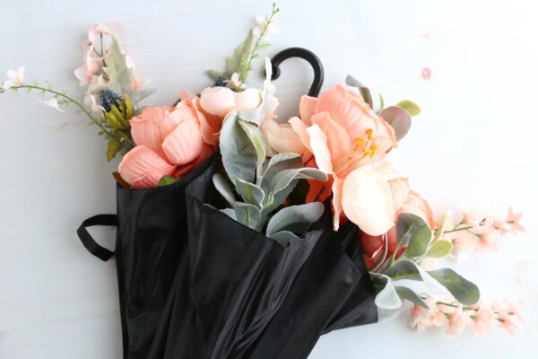 Flowers arranged in the umbrella with additional greenery.