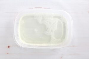 Small plastic tub filled with bleach water.