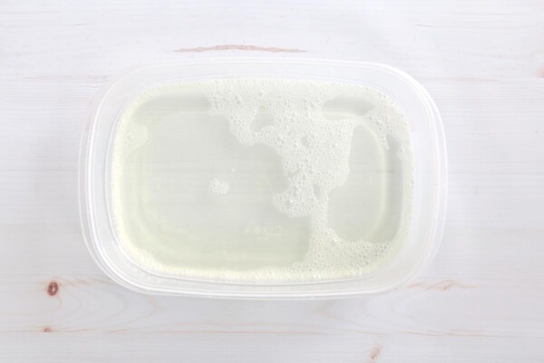 Small plastic tub filled with bleach water.