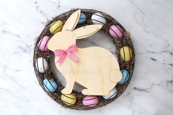Wood bunny cutout with bow tied around neck glued onto the wreath.