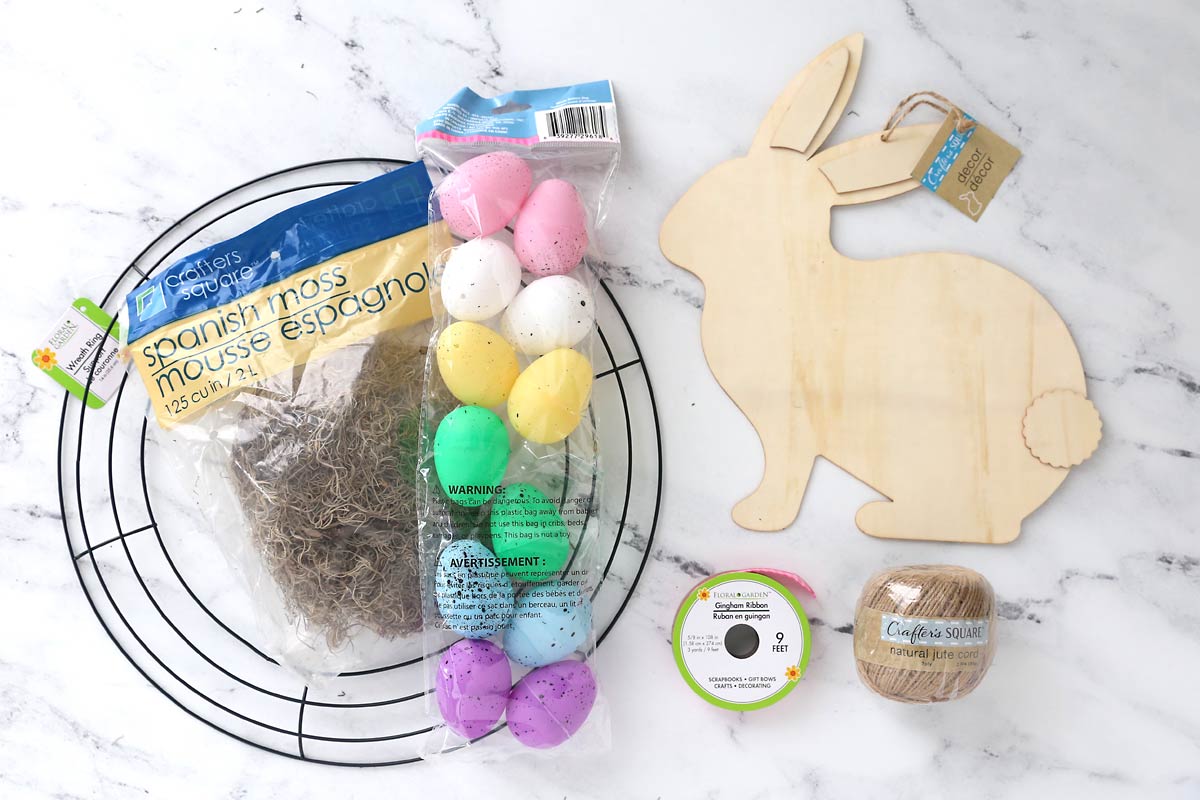 Supplies: round wreath form, spanish moss, speckled Easter eggs, wood bunny cutout, ribbon, jute.