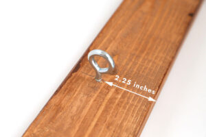 Hook screwed into underside of top piece, 2.25 inches from the front.