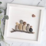 Family portrait made from pebbles and twig.