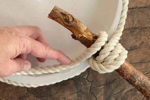 Rope looped around stick three times and glued to back of plate