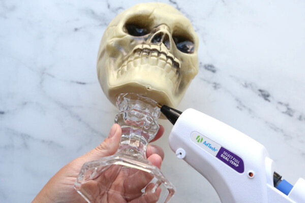 Hot gluing the candlestick to the skull