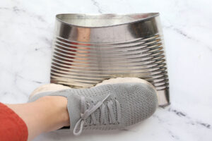 Foot smashing bottom of empty can