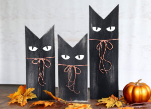 Three black cats made from wood