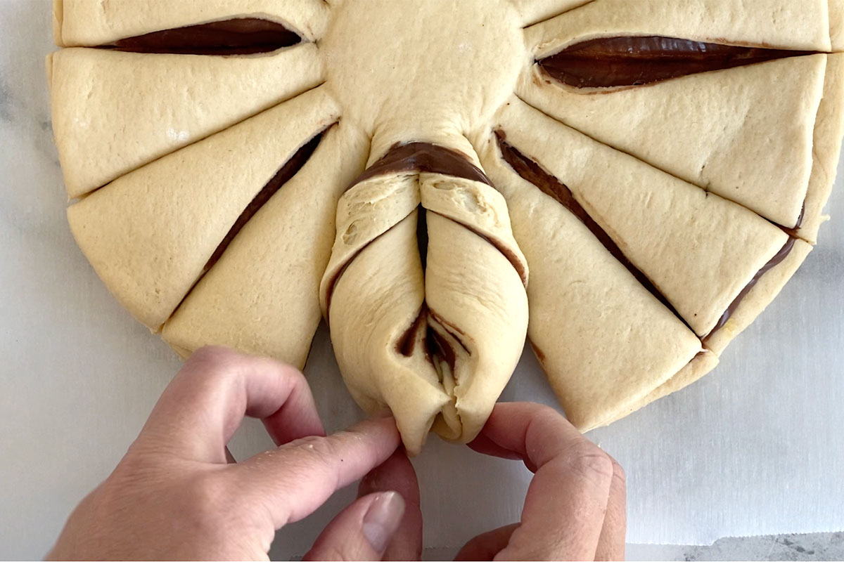 Two pieces lifted and twisted twice outward, edges pinched together.