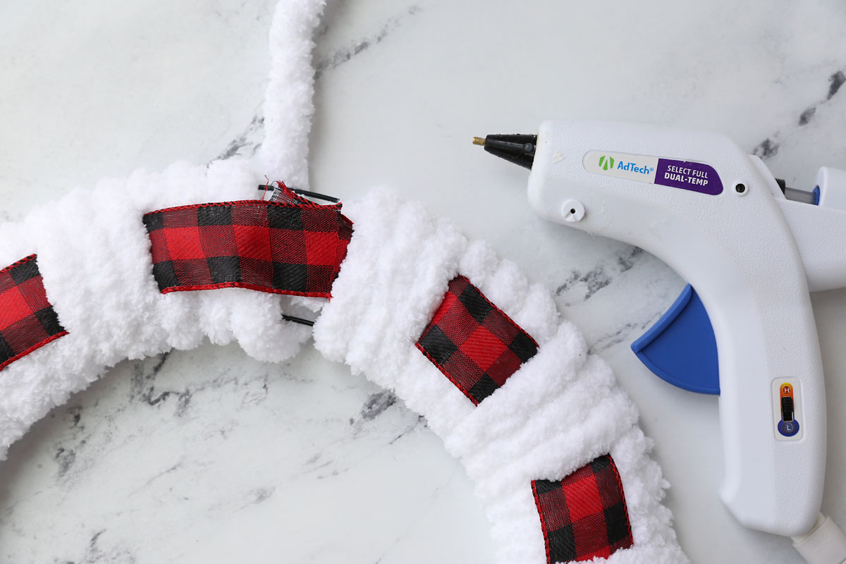 Overlapping the ribbon and hot gluing to secure.