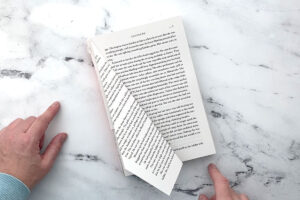 Top page of book folded down diagonally a second time.