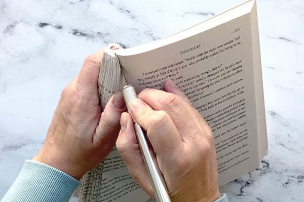 Using an exacto knife to cut off the rest of the book pages.