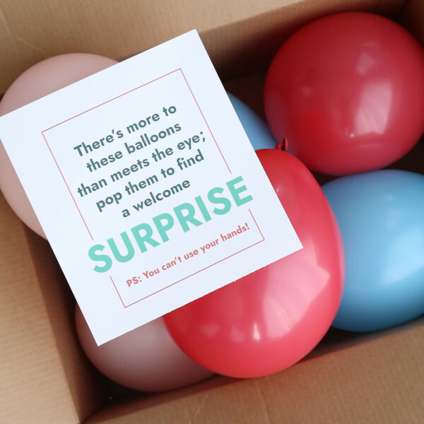 Balloons in a box with note.