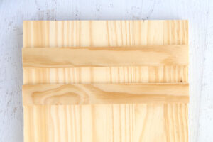 Two wood slat pieces cut to length to match the width of the wood board.