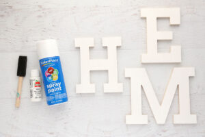White spray paint and acrylic paint; wood letters painted white.