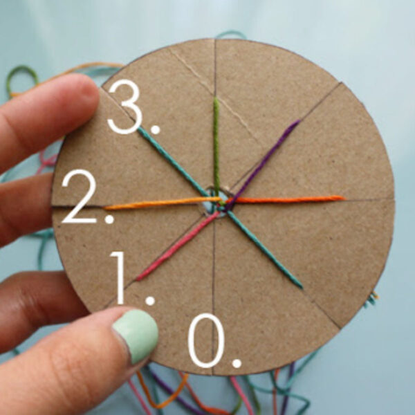 Weaving a friendship bracelet on a cardboard loom.