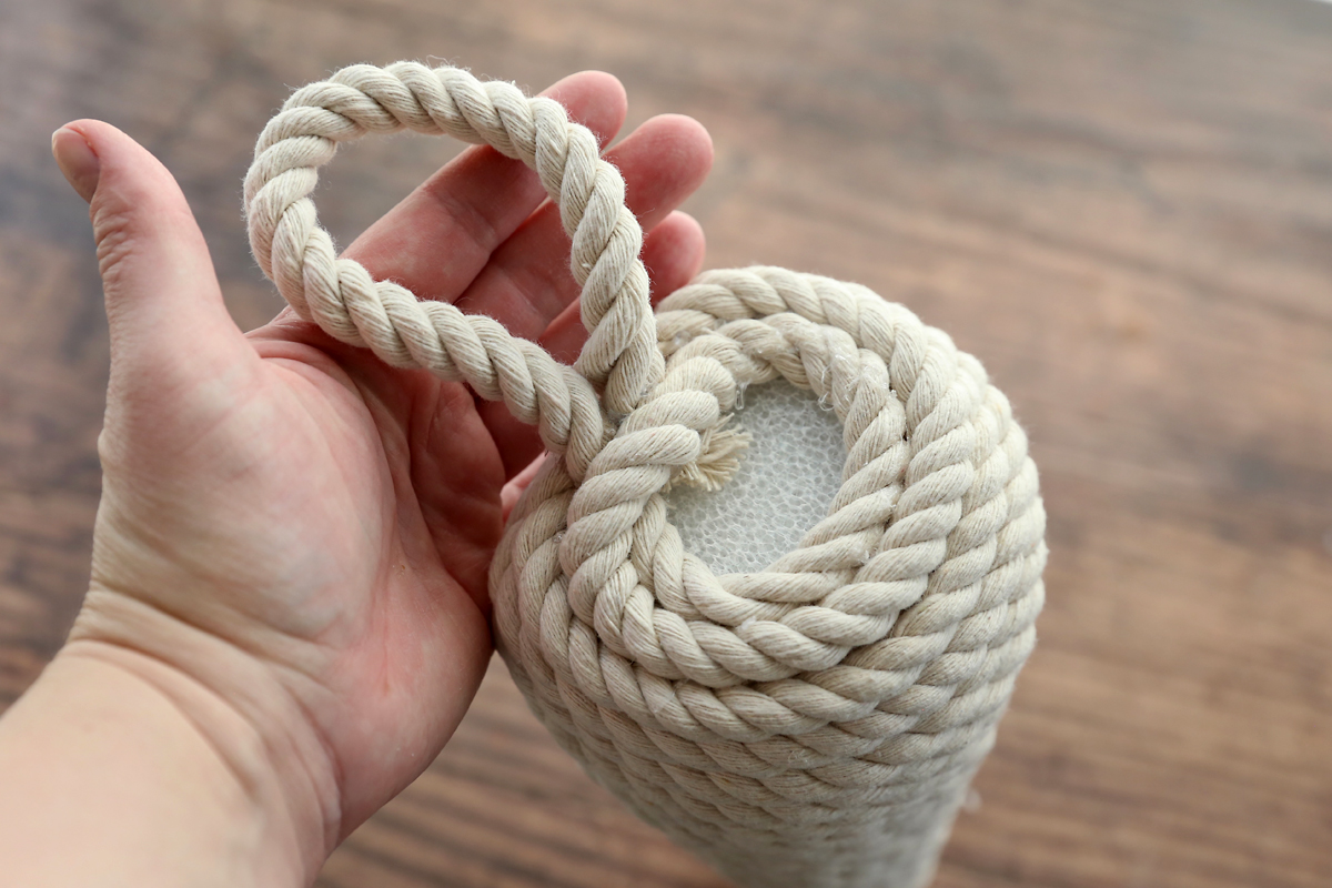 Foam cone covered in rope with loop at top.
