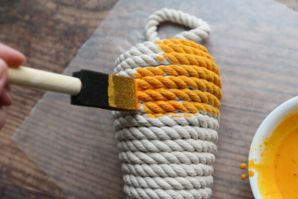 Using foam paintbrush to paint the carrot.