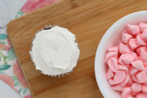 Cupcake with white frosting; pink mini marshmallow halves.