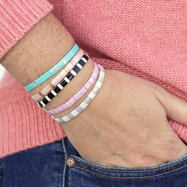 Person wearing tila bead bracelets.