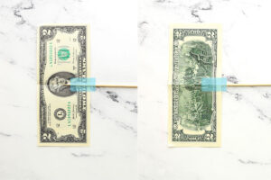 Dollar bill with skewer taped to it.