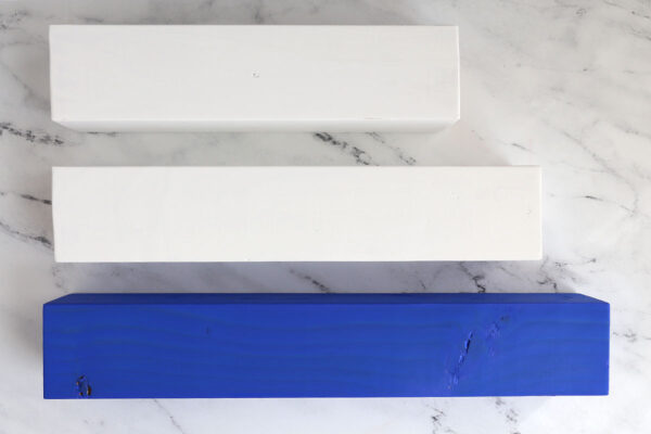 Longest wood piece painted blue, two other posts painted white.