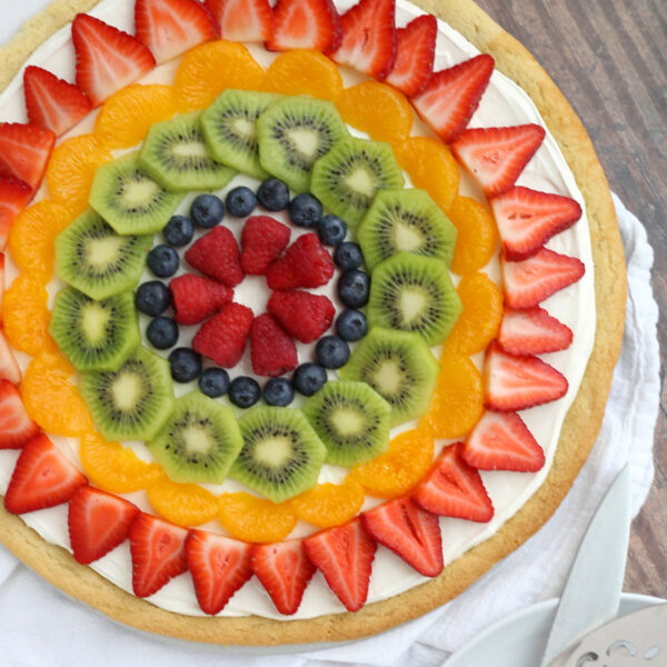 Fruit pizza topped with raspberries, blueberries, kiwi, mandarin oranges, and strawberries.