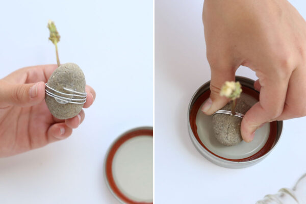 Placing a glue dot on the bottom of the stone, pressing it down into the lid of the jar.