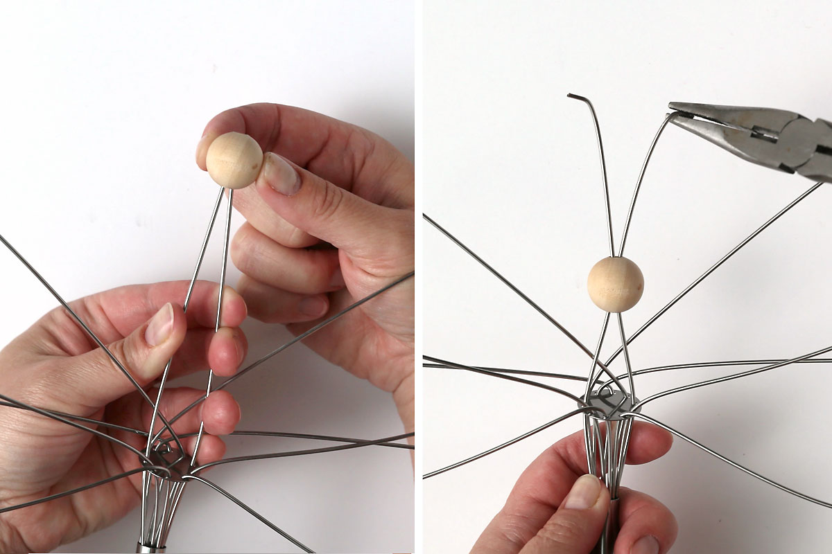 Sliding a bead onto the center loop that's been cut to create a head and antennae.