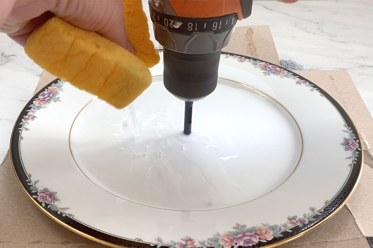 Squeezing water onto plate while drilling.