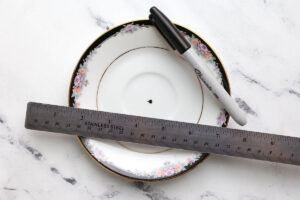 Plate with dot marked in the center; sharpie and ruler.