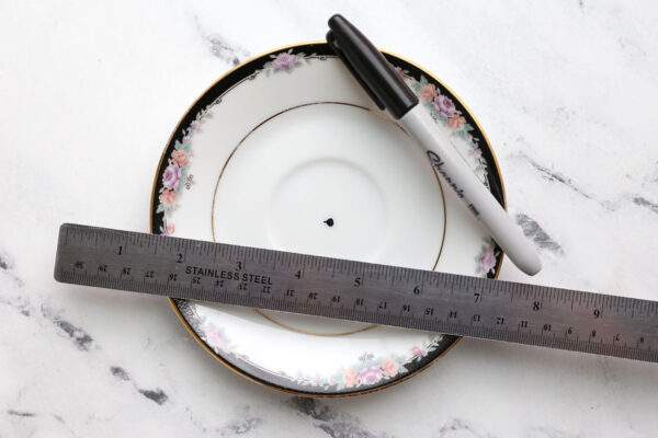 Plate with dot marked in the center; sharpie and ruler.