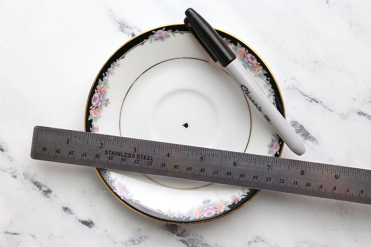 Plate with dot marked in the center; sharpie and ruler.