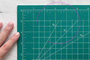 Curved piece of fishing line on a cutting mat.